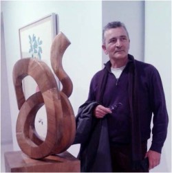 El artista junto a la obra seleccionada en la inauguración de la exposición colectiva